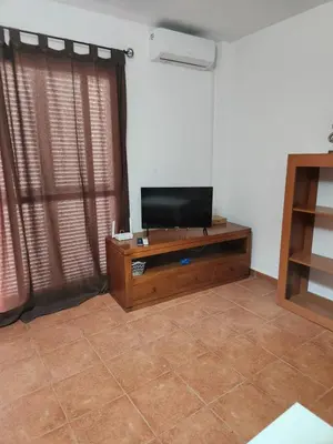 Una televisión o centro de entretenimiento en Casa Baja tranquila con terraza y jardín en Vera-Playa naturista!